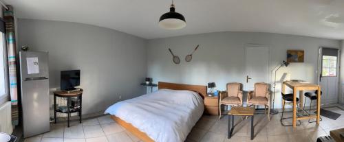 a bedroom with a bed and a table and chairs at Studio en baie de Somme in Villers-sur-Authie