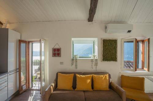 a living room with a couch and two windows at La Casa di Pietro in Blevio