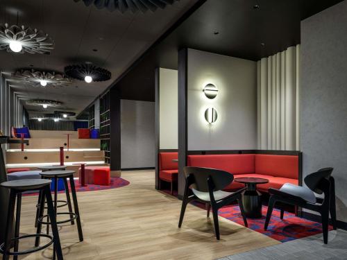 a lobby with a red couch and tables and chairs at Hotel Ibis Krakow Centrum in Krakow