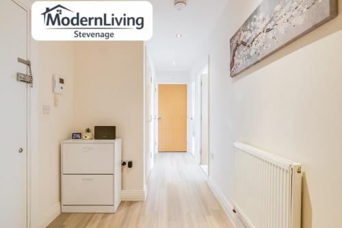 a white hallway with a staircase in a house at ModernLiving Stevenage 2 Bedroom Apartment Town Centre Sleeps 8 in Stevenage