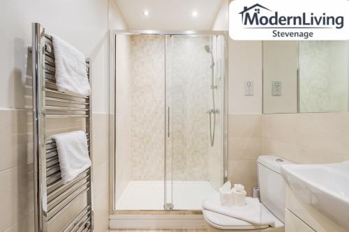 a bathroom with a shower and a toilet at ModernLiving Stevenage 2 Bedroom Apartment Town Centre Sleeps 8 in Stevenage