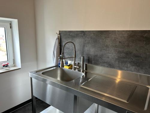 a stainless steel sink in a kitchen with a window at Ferienwohnung2 Renate Strohhöfer in Hirschaid