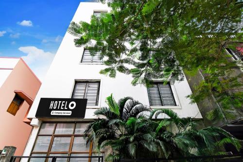 a white building with a hotel sign on it at Super Hotel O Tagore Park Laskarhat Formerly Shankar Guest House in Kolkata