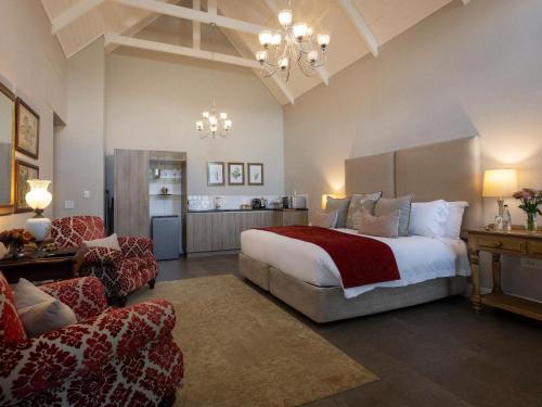 a bedroom with a bed and a living room at Meerendal Boutique Hotel in Durbanville