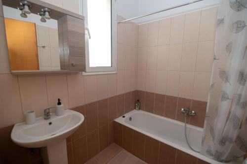 a bathroom with a sink and a bath tub at Olive Paradise Maison in Kos