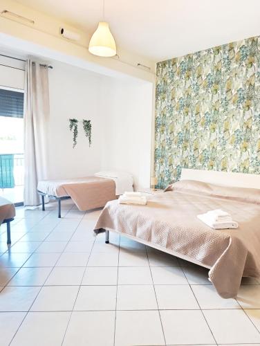 a bedroom with two beds and a tiled floor at B&B Damiani in Santa Maria di Castellabate