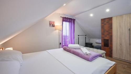 a bedroom with a large white bed and a window at Villa Vinea by Villas Guide in Novakovec