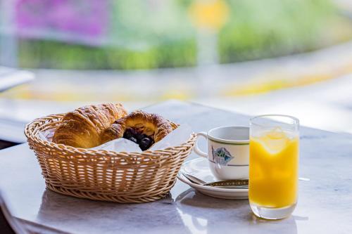 a basket of bread next to a cup of orange juice at ホテルマルセイユ in Shimoda