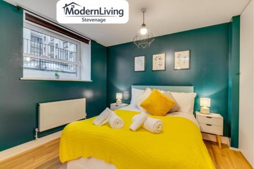 a bedroom with a yellow bed and green walls at ModernLiving Stevenage 1 Bedroom Apartment Town Centre Sleeps 4 in Stevenage