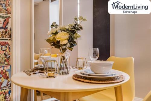 a white table with a vase of flowers on it at ModernLiving Stevenage 1 Bedroom Apartment Town Centre Sleeps 4 in Stevenage