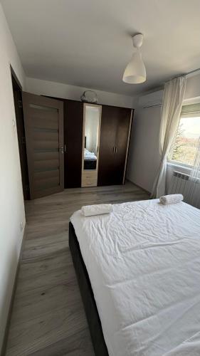 a bedroom with a large white bed and a window at Lion Crib in Bacău