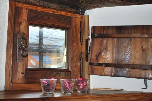 four glasses sitting on a table next to a window at Baita del Plan in Pragelato