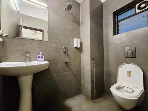 a bathroom with a sink and a toilet and a mirror at hotel Prime Plaza Newtown in kolkata