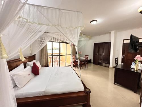 a bedroom with a bed with a canopy at Sienna Beach Hotel - Entebbe in Entebbe