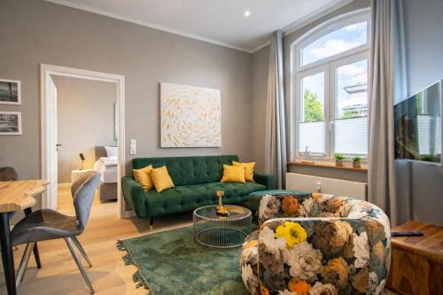 a living room with a green couch and a table at Inselrose in Juist