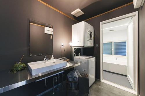 a bathroom with a sink and a refrigerator and a window at BLIKIYA Doma in Fujiyoshida