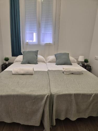 a bedroom with two beds with pillows and a window at Pinedo Playa Holiday 2 in Valencia