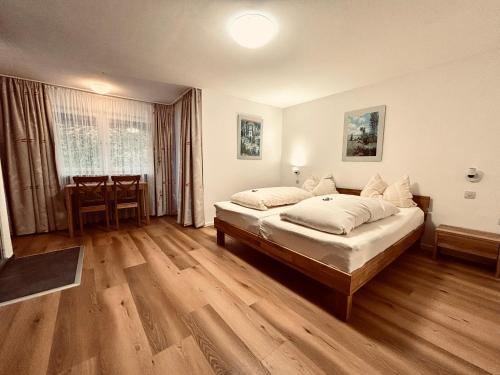 a bedroom with a large bed and a table at Hotel Tannenhof in Egmating