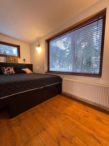 a bedroom with a bed and a large window at Art space Bundulis in Saulkrasti