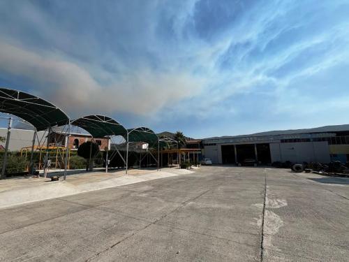 a parking lot with a building with green roofs at Caco Camper Parking in Berat