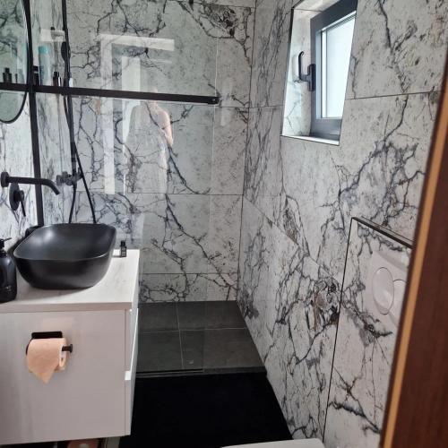 a bathroom with a black and white marble wall at Modern 4 stars Apartment with terace & free parking in Šibenik