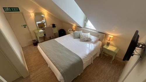 a small bedroom with a bed and a bathroom at Centennial Hotel in Cambridge