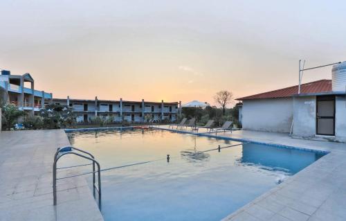 a large swimming pool in the middle of a building at Camp Leo Aaranya Resort in Sasan Gir