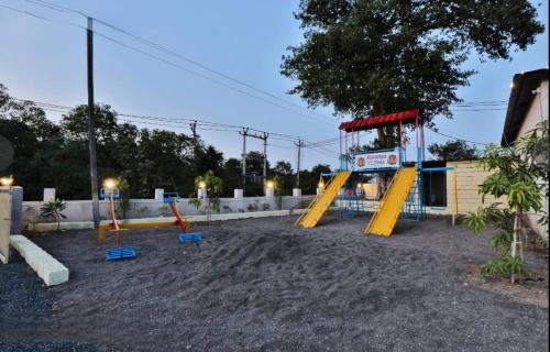 an empty playground with a swing set in a yard at Camp Leo Aaranya Resort in Sasan Gir