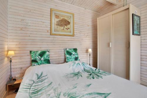 a bedroom with a large bed with green pillows at Chalet 2 FLAMANT ROSE in Roquebrune-sur-Argens