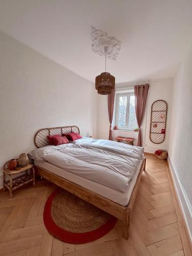 a bedroom with a large bed with a rug on the floor at La Maison de Jacob in La Chaux-de-Fonds