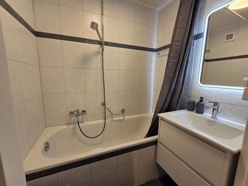 a bathroom with a shower and a tub and a sink at La Maison de Jacob in La Chaux-de-Fonds