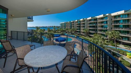 a balcony with a table and chairs and a pool at Phoenix on the Bay 1328 in Orange Beach