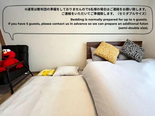 two beds sitting next to each other in a bedroom at BUDDY HOUSE - Newコスパ重視! サンタプレゼントパーク10分! カムイリンクス28分! コンビニ徒歩3分! 旭川鷹栖インター5分! 商業施設すぐ! in Asahikawa