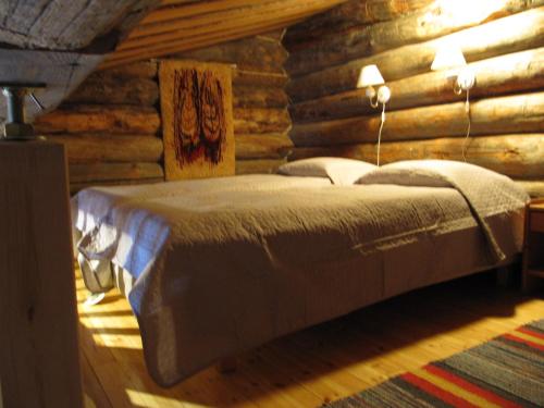 a bedroom with a bed in a log cabin at Rukanpovi RP 7 - Studio in Ruka