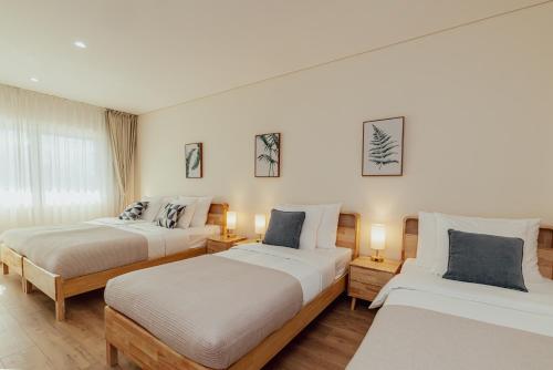 two beds in a room with two lamps at Hotel ORJEN sport & pleasure in Trebinje