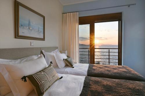a bedroom with two beds and a view of the ocean at Seafront Marine Villa with private sea access - Iris Villas Lefkada in Sivota