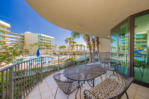 a balcony with a table and chairs and a pool at Phoenix on the Bay 1109 condo in Orange Beach