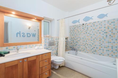 a bathroom with a tub and a toilet and a sink at TEKCE Villa Mae N3 in Yeniköy