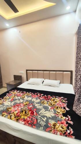 a bedroom with a bed with a floral bedspread at Royal guest house in Gorakhpur