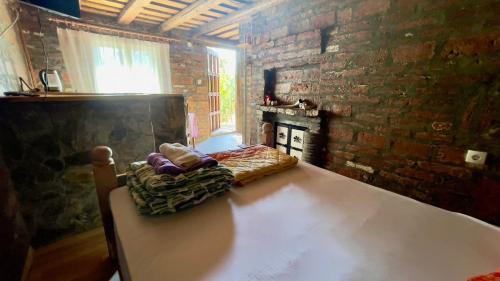 a room with a table and a brick wall at Apartmani Todorovic Ugore Vrdnik in Vrdnik