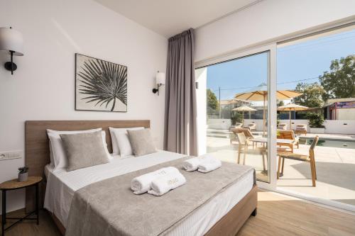 a bedroom with a bed with towels on it at Sinati Luxury Studios Laganas Zakynthos in Laganas