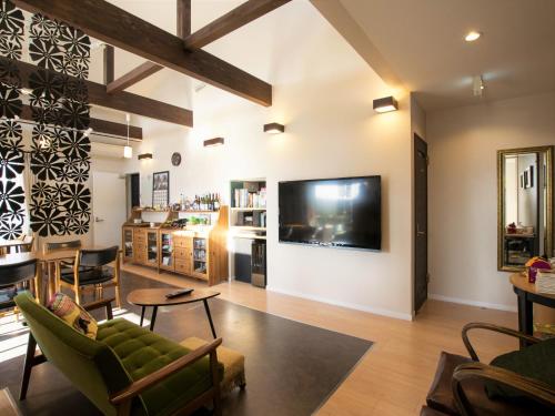 a living room with a large flat screen tv on the wall at North Gate Inn ABIRA in Chitose