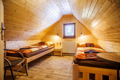 a room with two beds in a wooden cabin at Chata U Valentů in Červená Voda