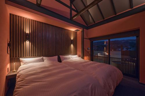 a bedroom with a large white bed with a window at Wakasa Annex in Nara