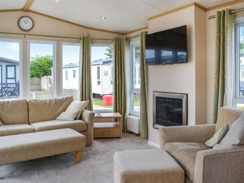 a living room with two couches and a fireplace at Lavender Lodge in Patrington