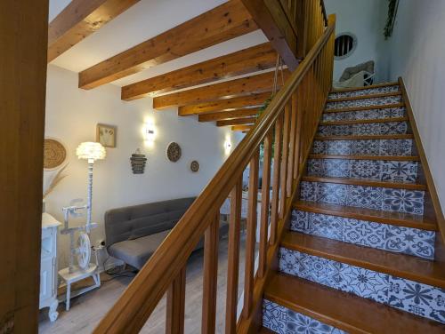 a wooden staircase in a living room with a couch at Cozy AM Spa and Cinema in Andance
