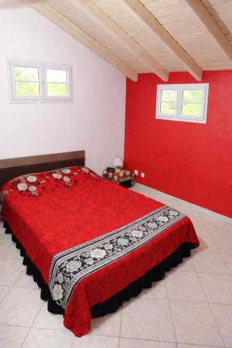 a red bedroom with a bed with a red wall at Appartement 5 pers proche plage Capesterre in Capesterre-Belle-Eau