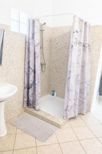 a bathroom with a shower and a bath tub at Appartement 5 pers proche plage Capesterre in Capesterre-Belle-Eau