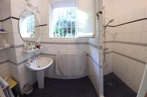 a white bathroom with a sink and a shower at Maison vue mer exceptionnelle in Le Lavandou