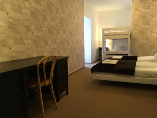 a bedroom with a bed and a desk with a mirror at Penzion Fojtstvi in Olomouc